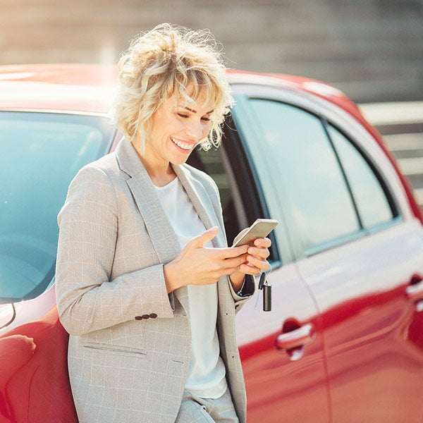 standing by car using phone
