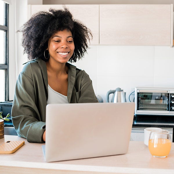 lady using laptop while in the kitchen