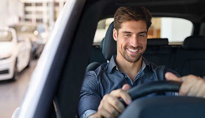 Happy man driving a new car
